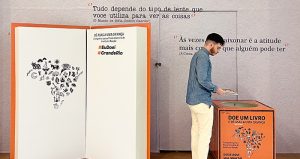 homem doando livro para Festa Literária do Instituto Reação